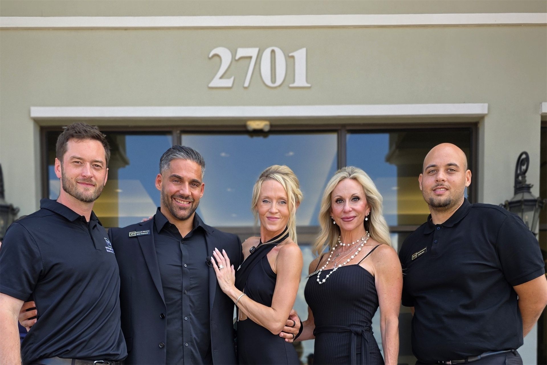 The Vitalé Health team in black attire outside their Vero Beach office.