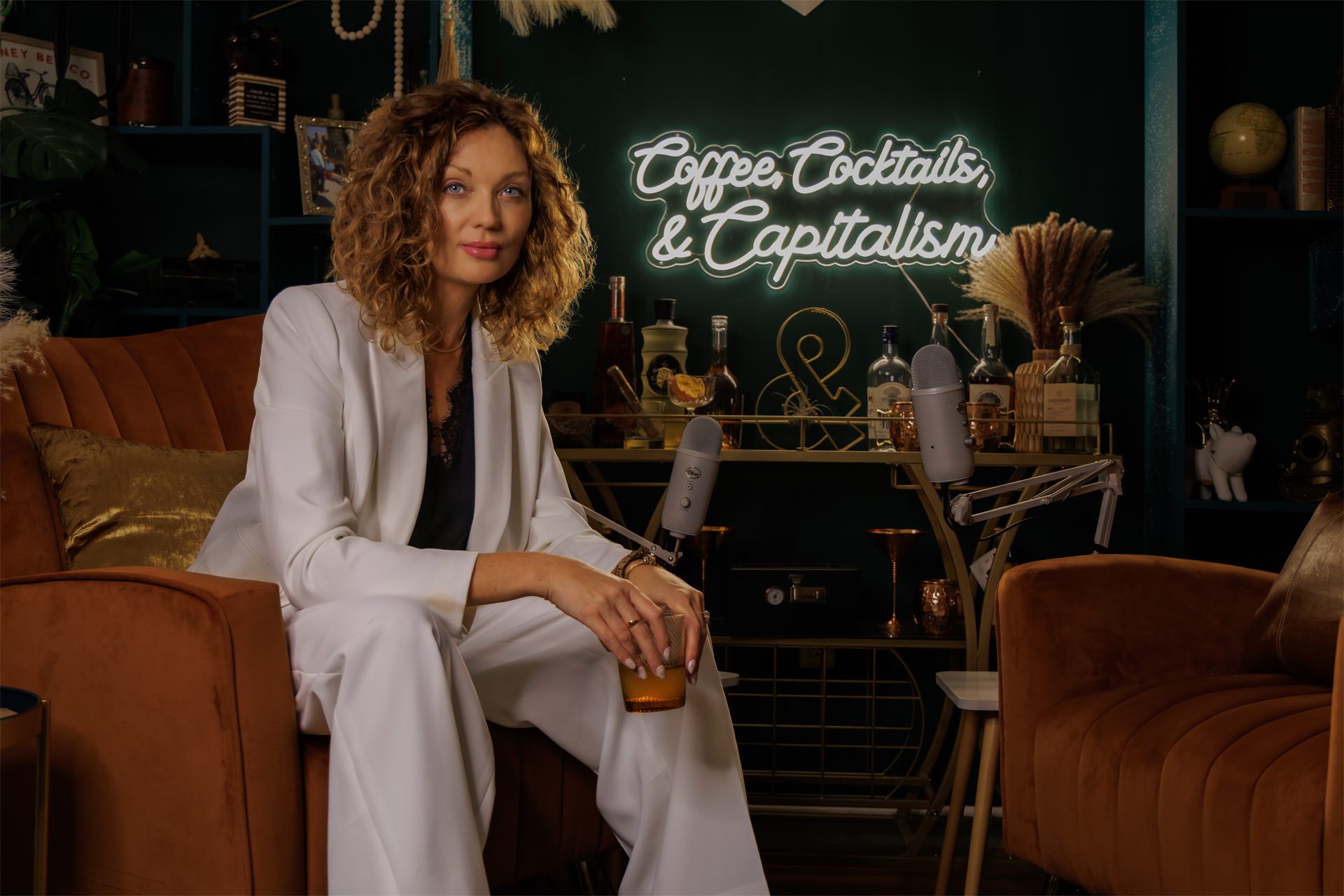 Morgen Reynolds hosting the Coffee, Cocktails & Capitalism podcast in a warmly lit studio.